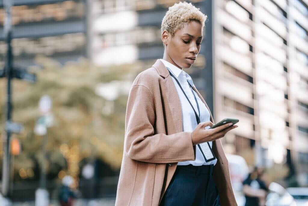 Woman checking messages on her phone. Learn why text messaging is the new normal.